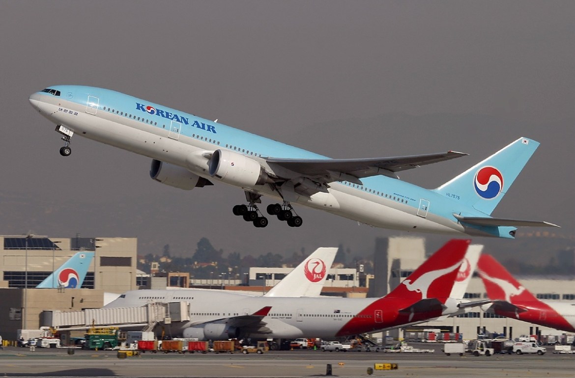 Un coréen Air Boeing 777 décoller avec des avions d'autres compagnies aériennes en arrière-plan